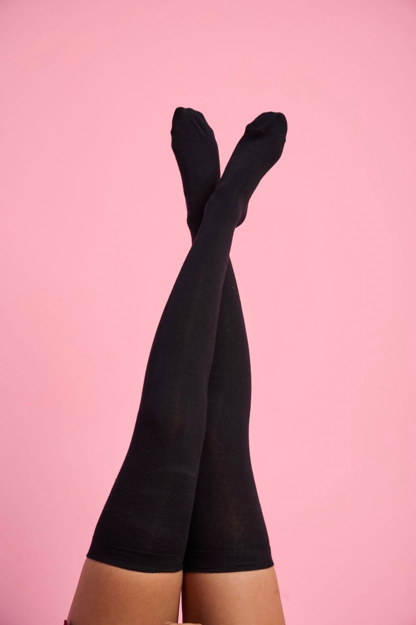 Model is wearing black high knee socks