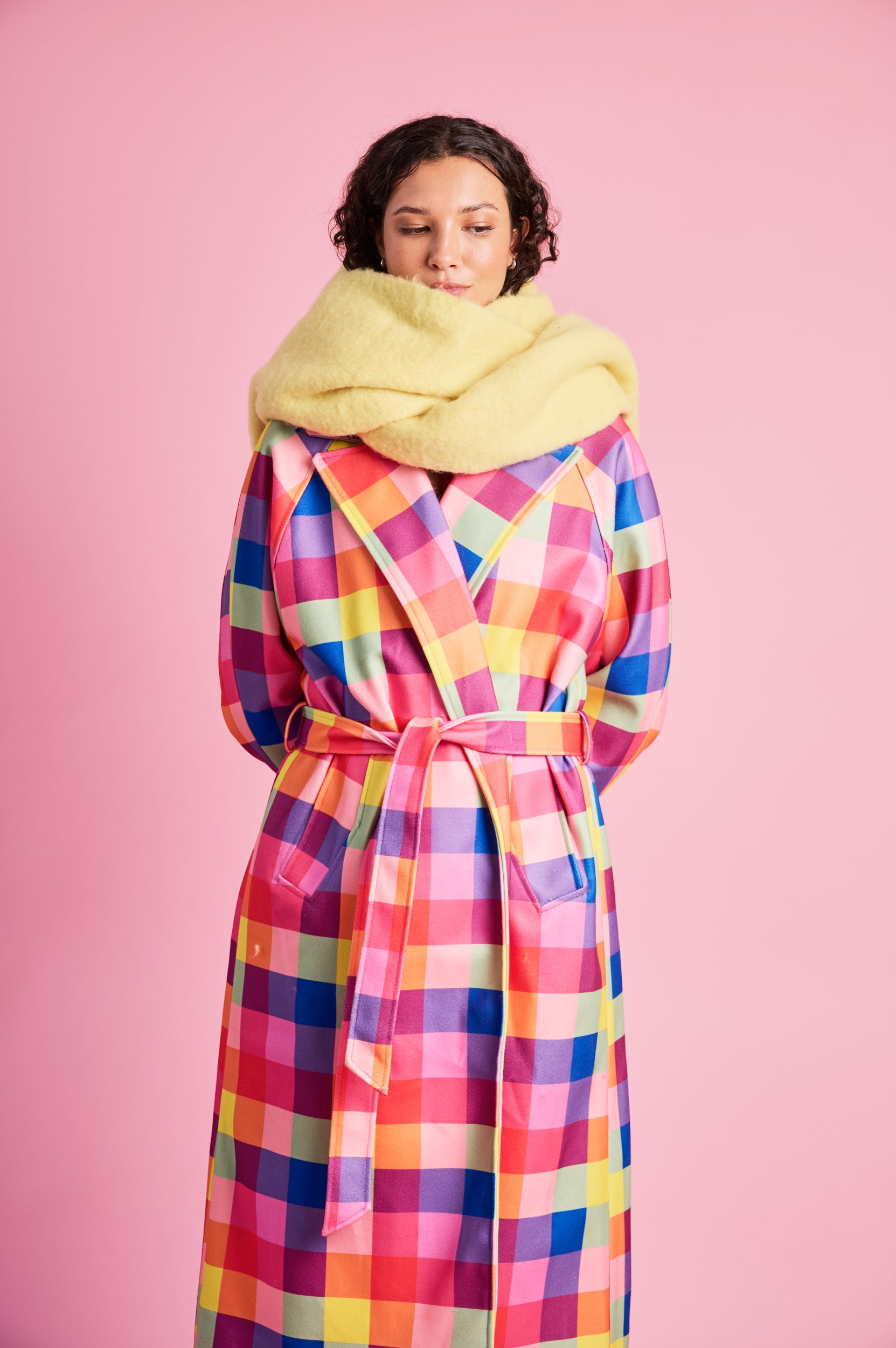 Model is wearing a yellow scarf and a multi check coat