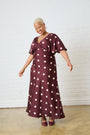 Model is wearing a burgundy satin maxi dress with burgundy shoes by Me&B