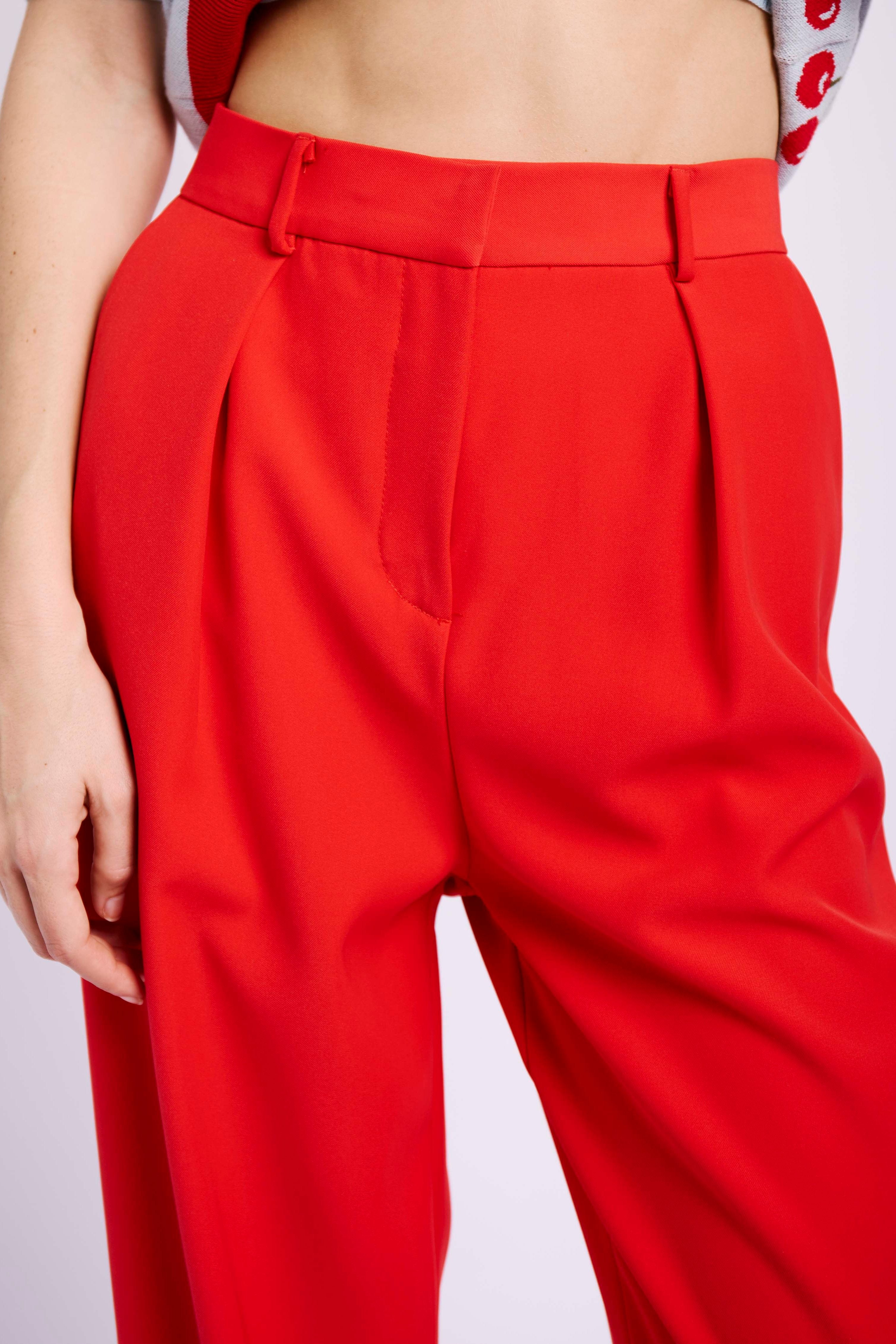 Model wearing red suit and cherry jumper