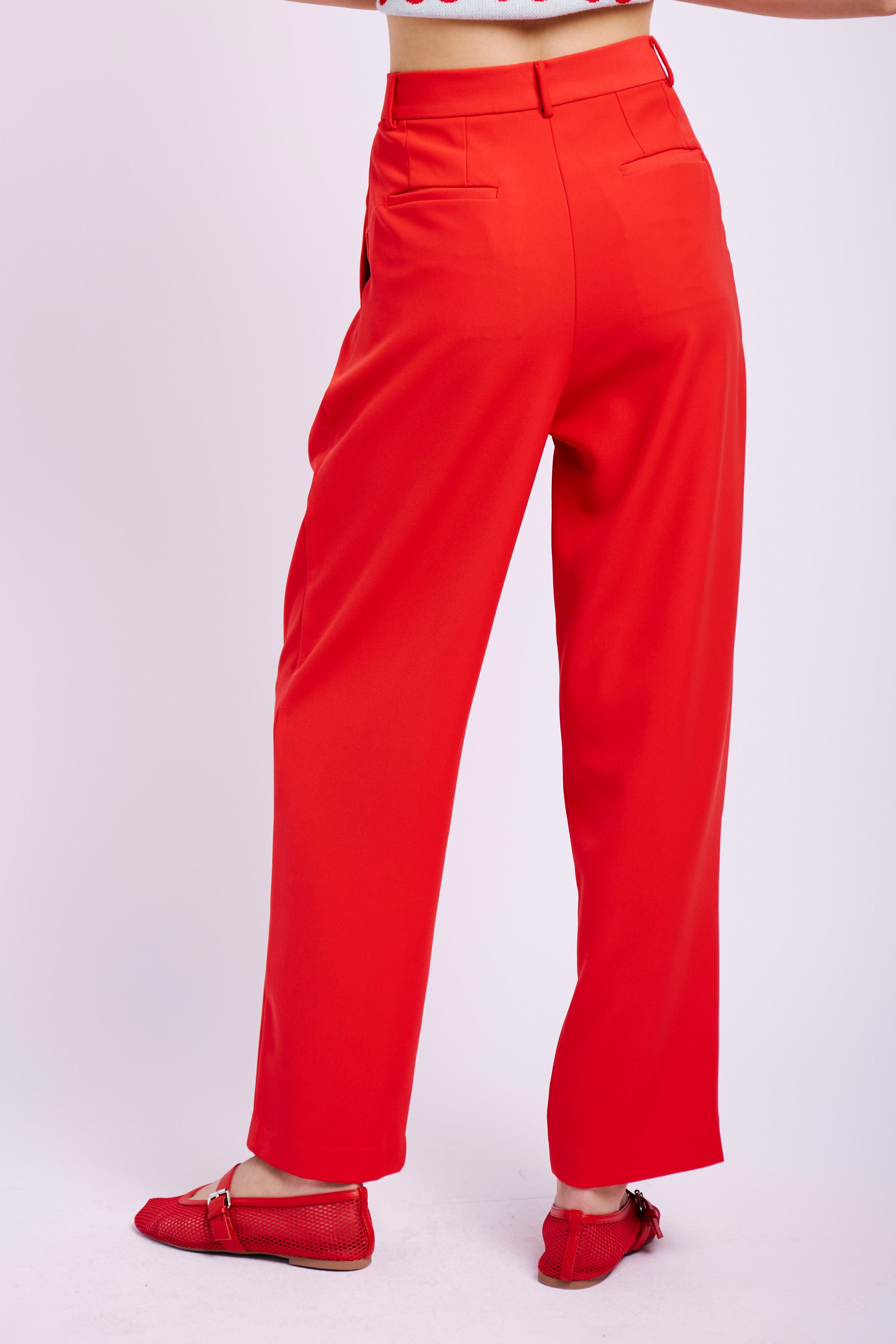 Model wearing red suit and cherry jumper