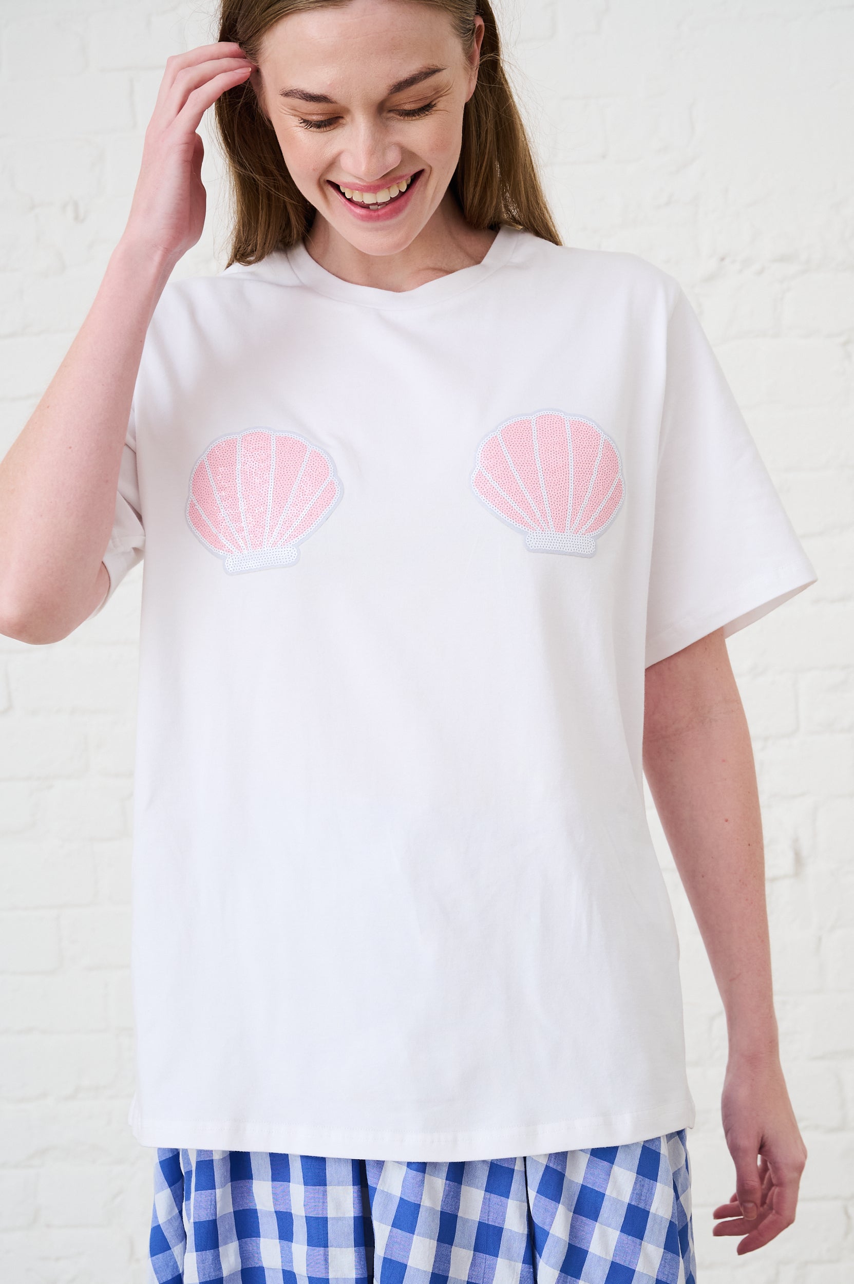 Model is wearing a white T-Shirt with pink shells