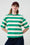 Model is wearing a green and white striped T-Shirt with a brown cap and jeans