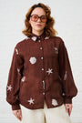 Model is wearing a brown bellow sleeve shirt withe shell embroidery by Me&B
