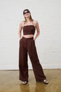 Model is wearing a linen brown crop top with brown linen wide leg pants and brown sandals by Me&B