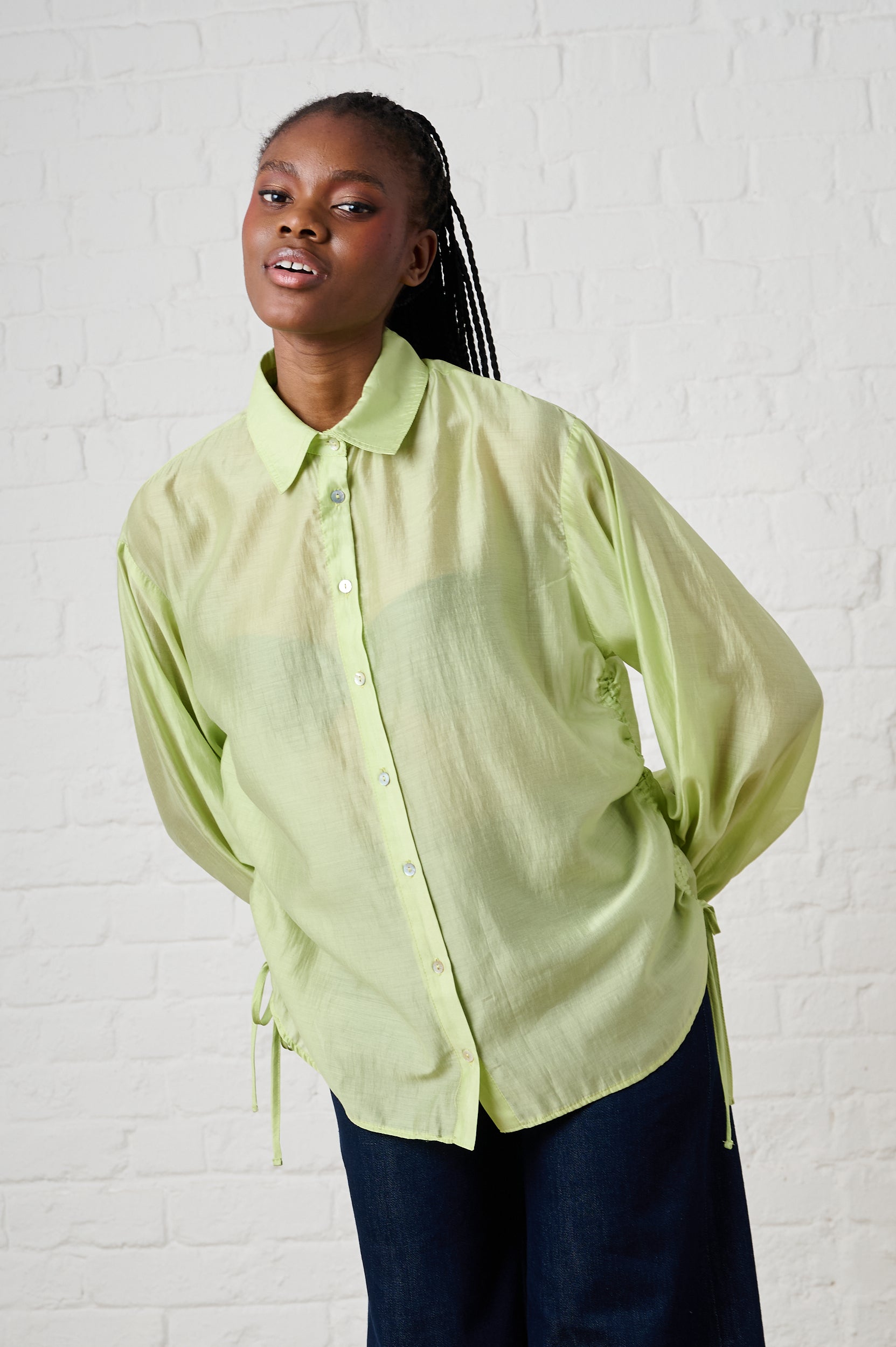 Model is wearing a sheer mint bellow sleeve shirt