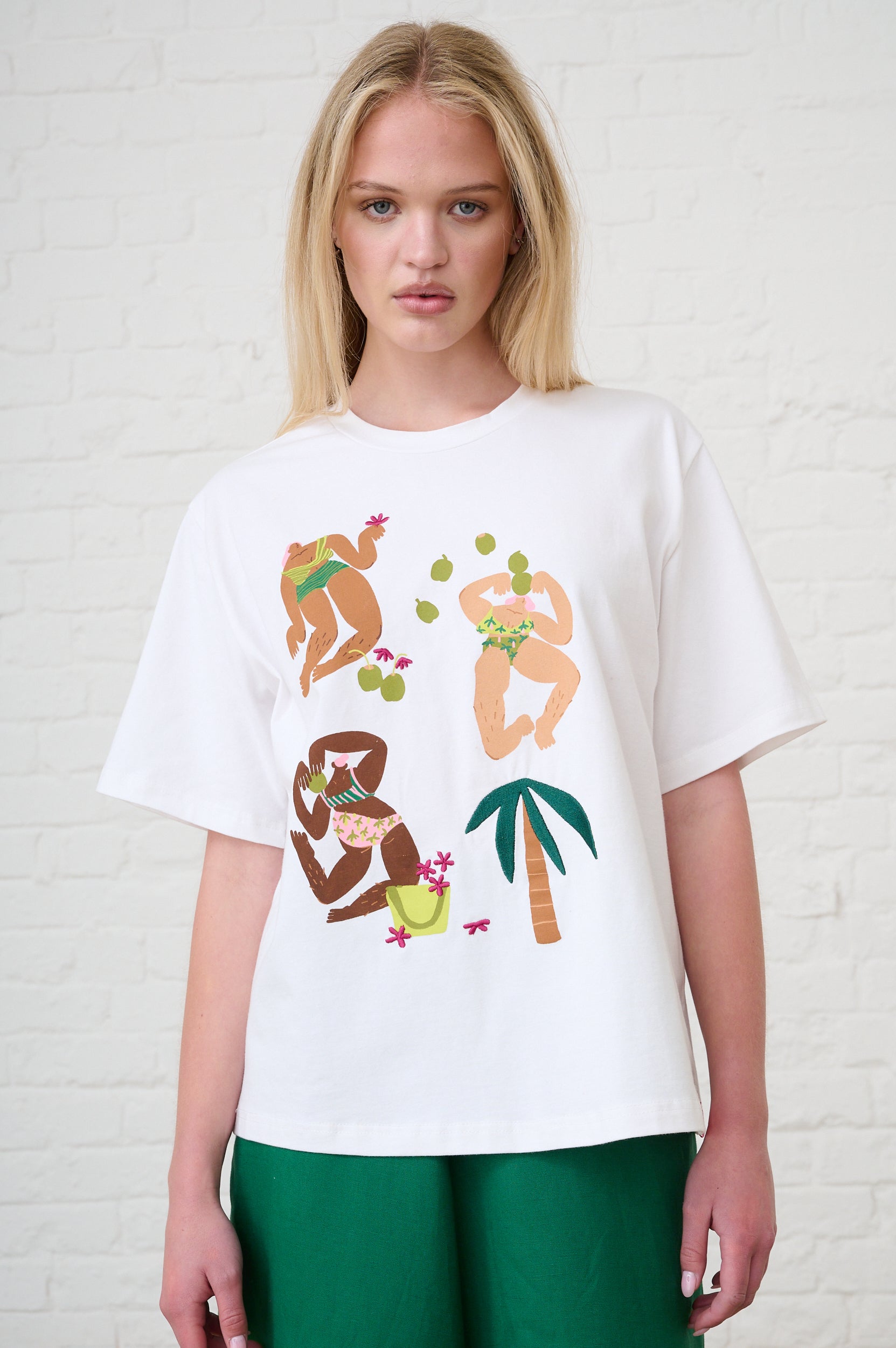 Woman wearing a white t-shirt with colorful graphic designs on a white background