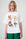Woman wearing a white t-shirt with colorful graphic designs on a white background
