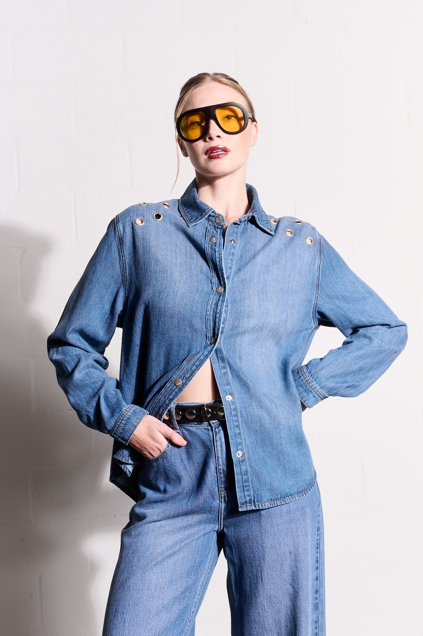 Model is wearing a denim top with denim jeans