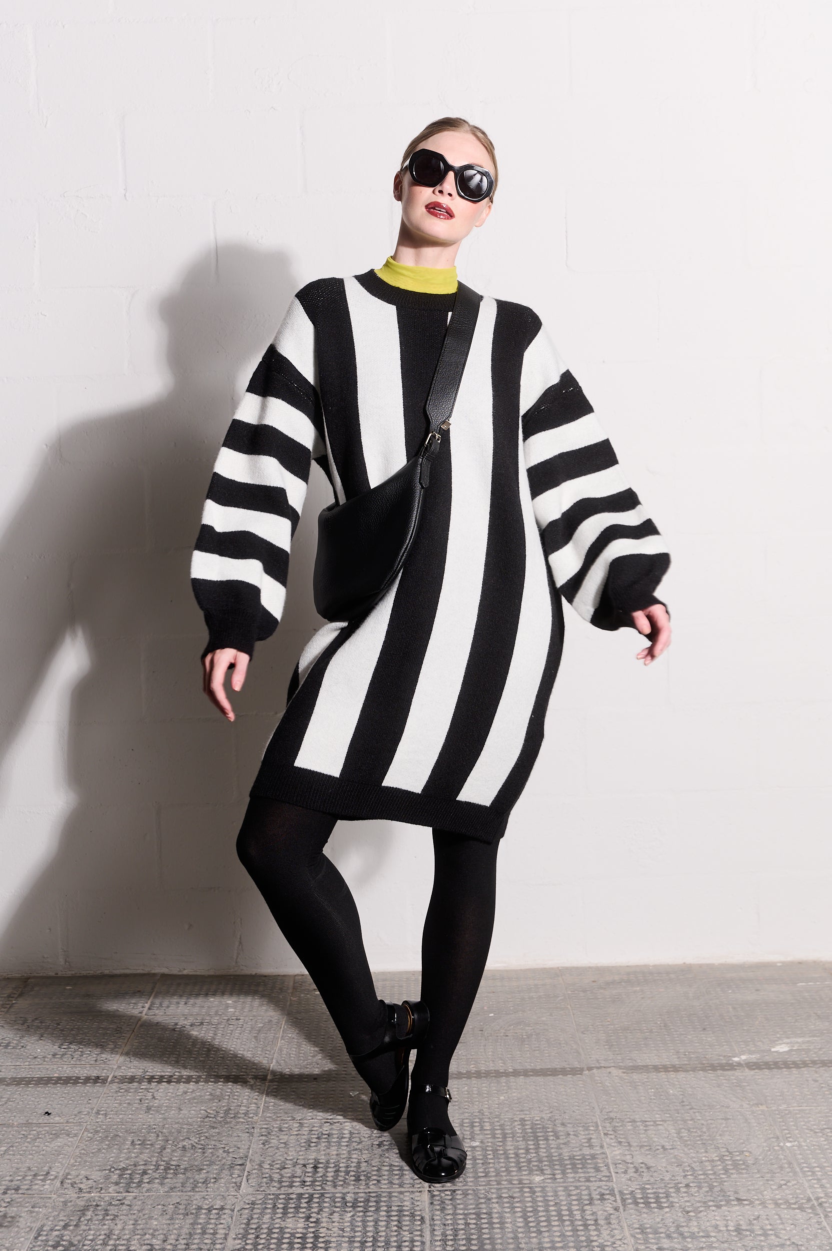 Model is wearing black and white striped long sleeve jersey dress