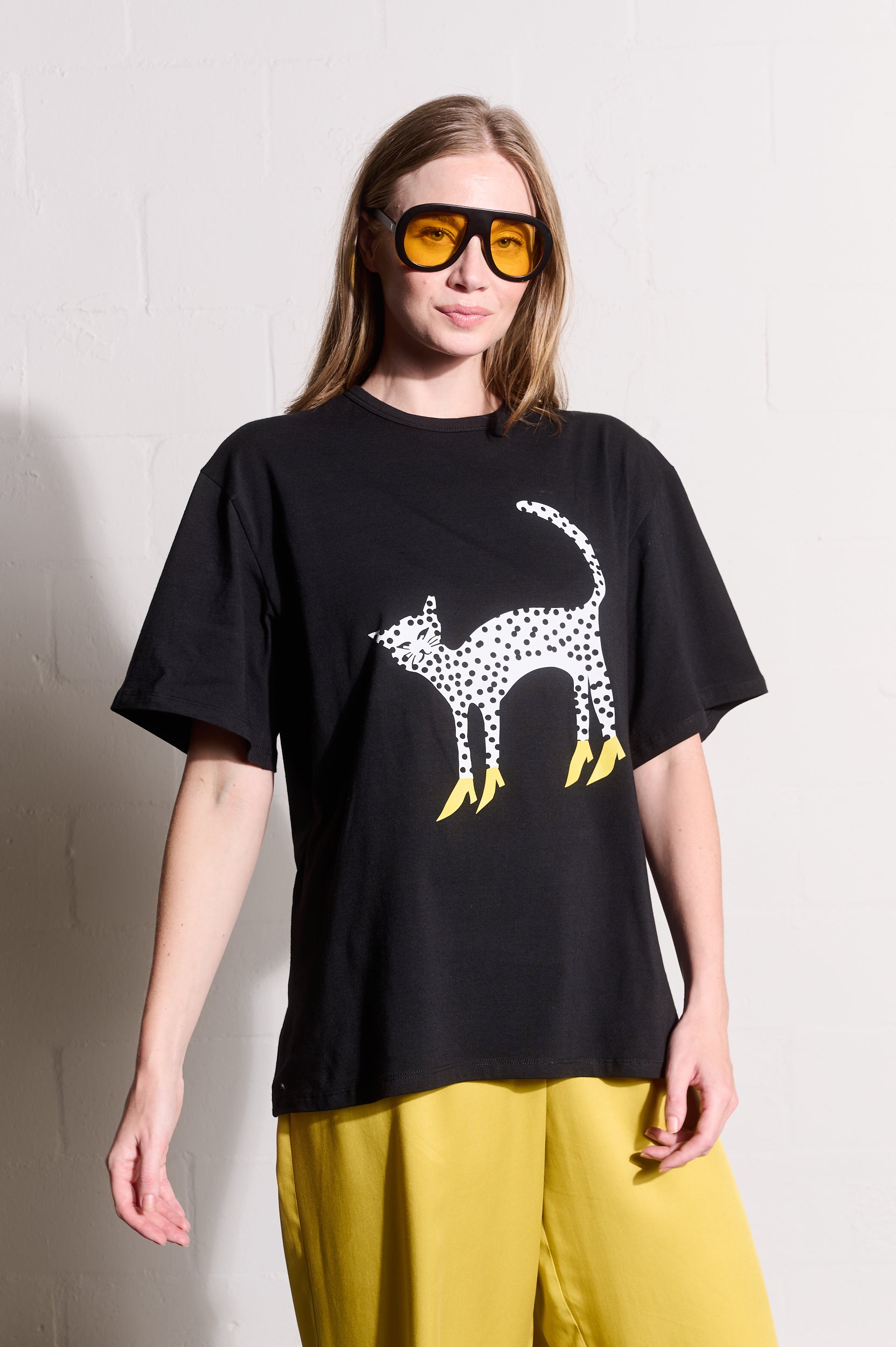 Model is wearing a black Tee Shirt with yellow pants and sunglasses