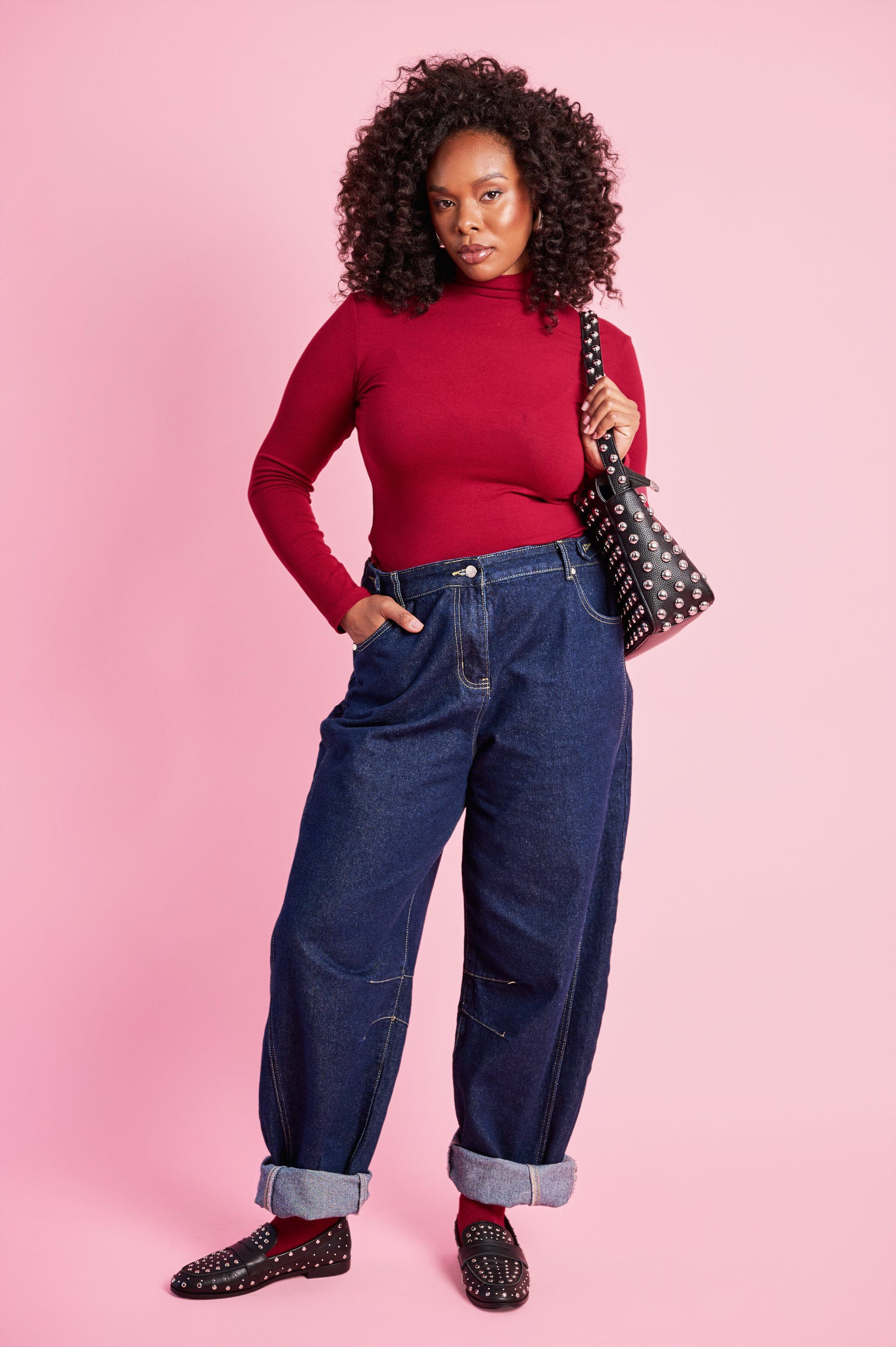 Model is wearing a long sleeve polo with dark denim jeans