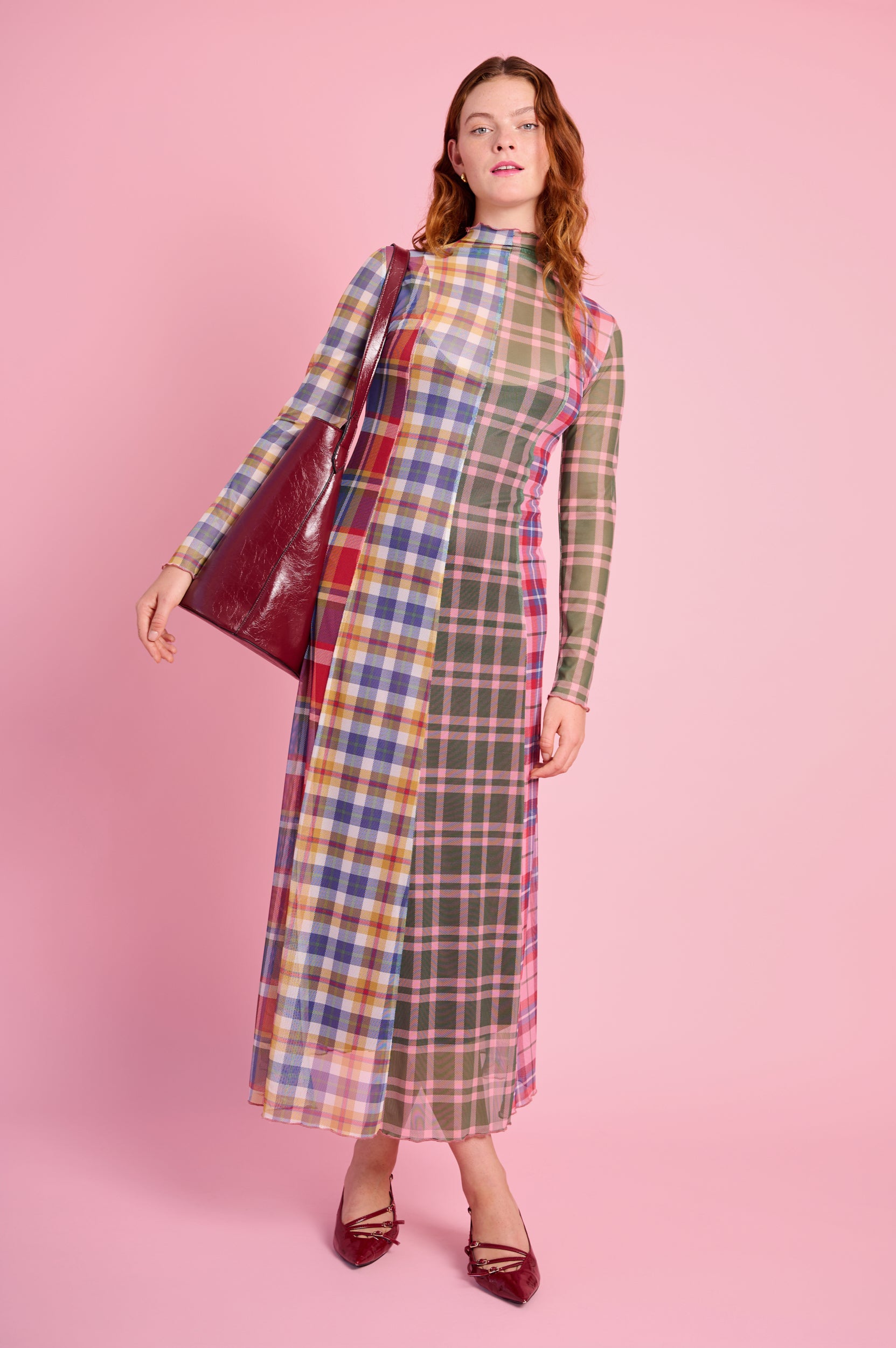 Model is wearing a multicheck mesh long sleeve polo neck dress with burgundy shoes and a burgundy bag