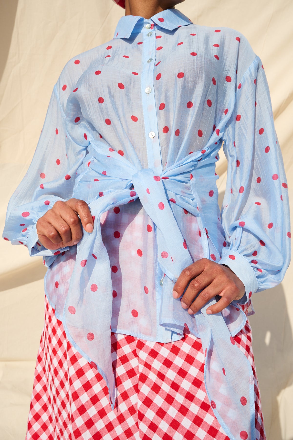 Light blue blouse with red polka dots, long sleeves and a tie waist