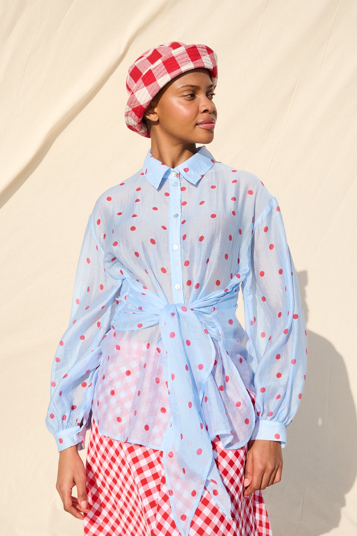 Light blue blouse with red polka dots, long sleeves and a tie waist