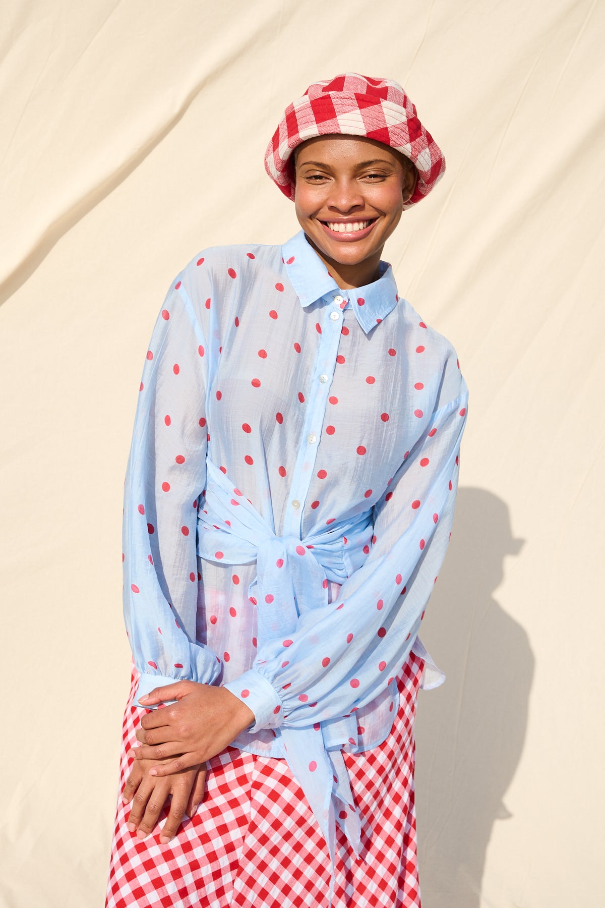 Light blue blouse with red polka dots, long sleeves and a tie waist