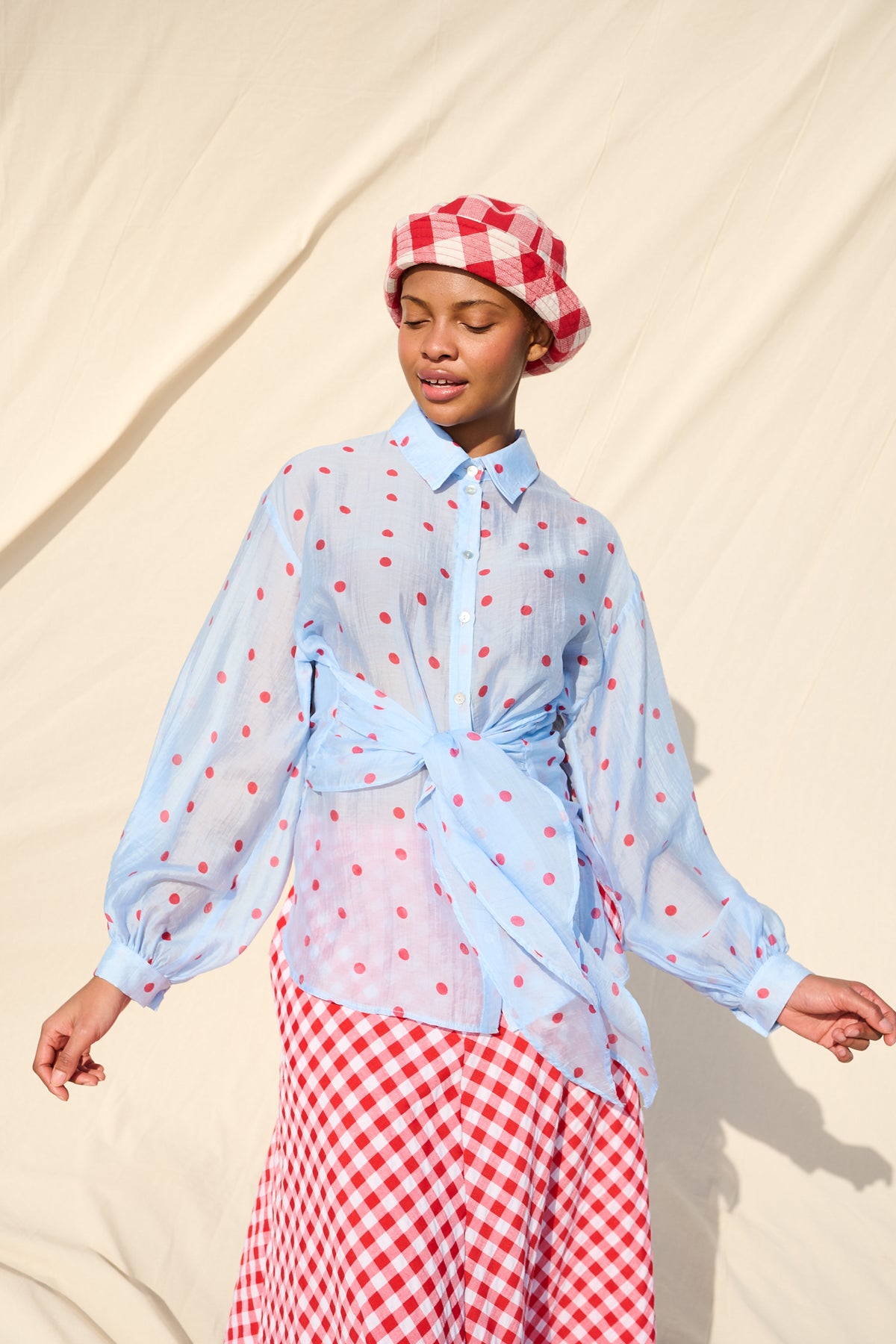 Light blue blouse with red polka dots, long sleeves and a tie waist