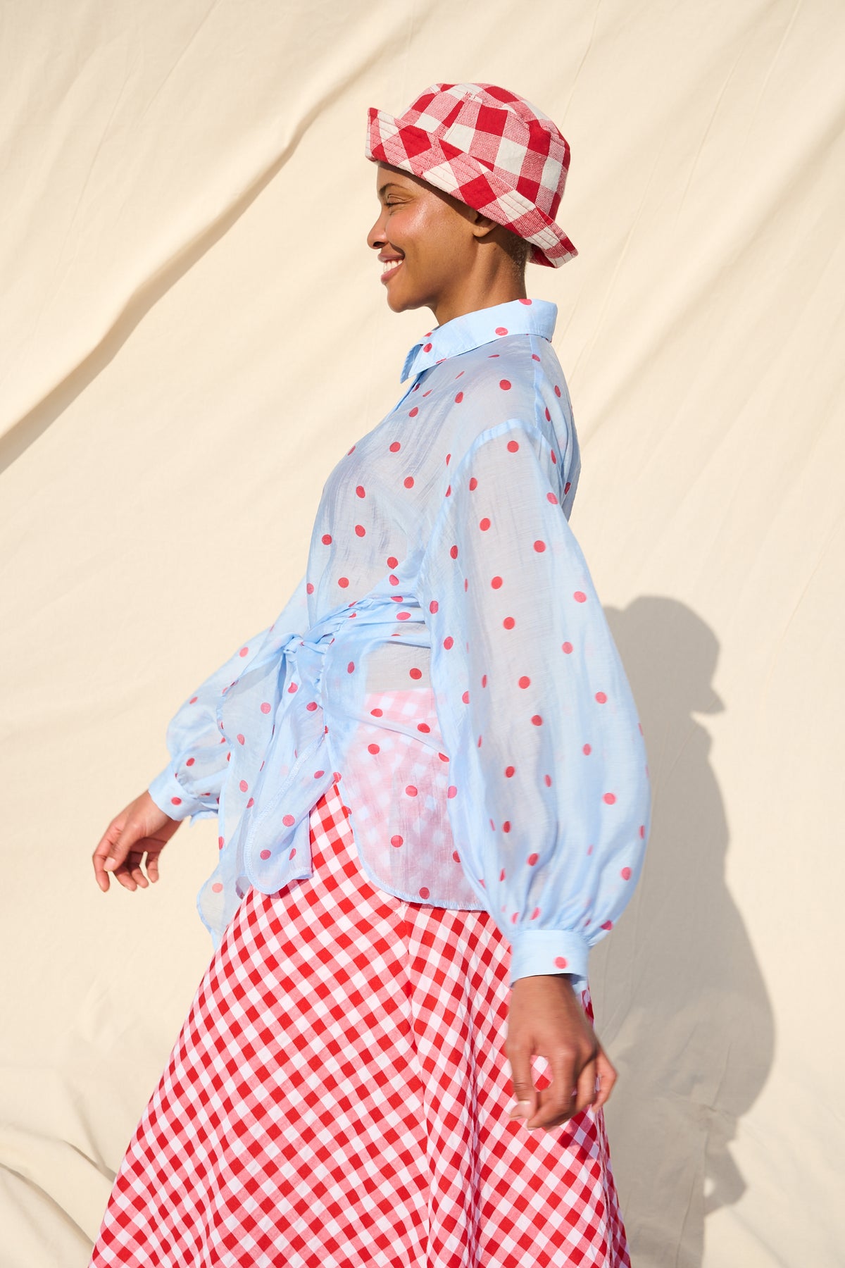 Light blue blouse with red polka dots, long sleeves and a tie waist