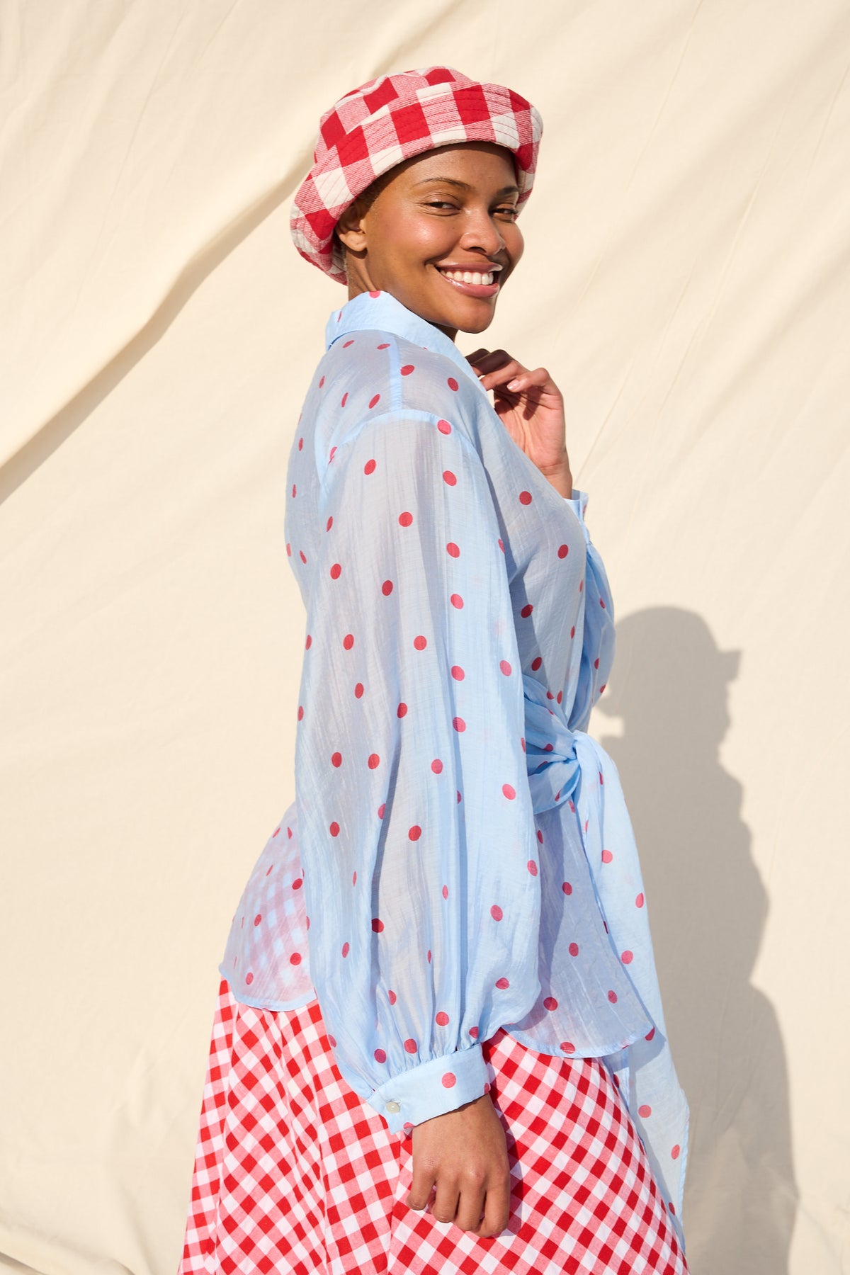 Light blue blouse with red polka dots, long sleeves and a tie waist