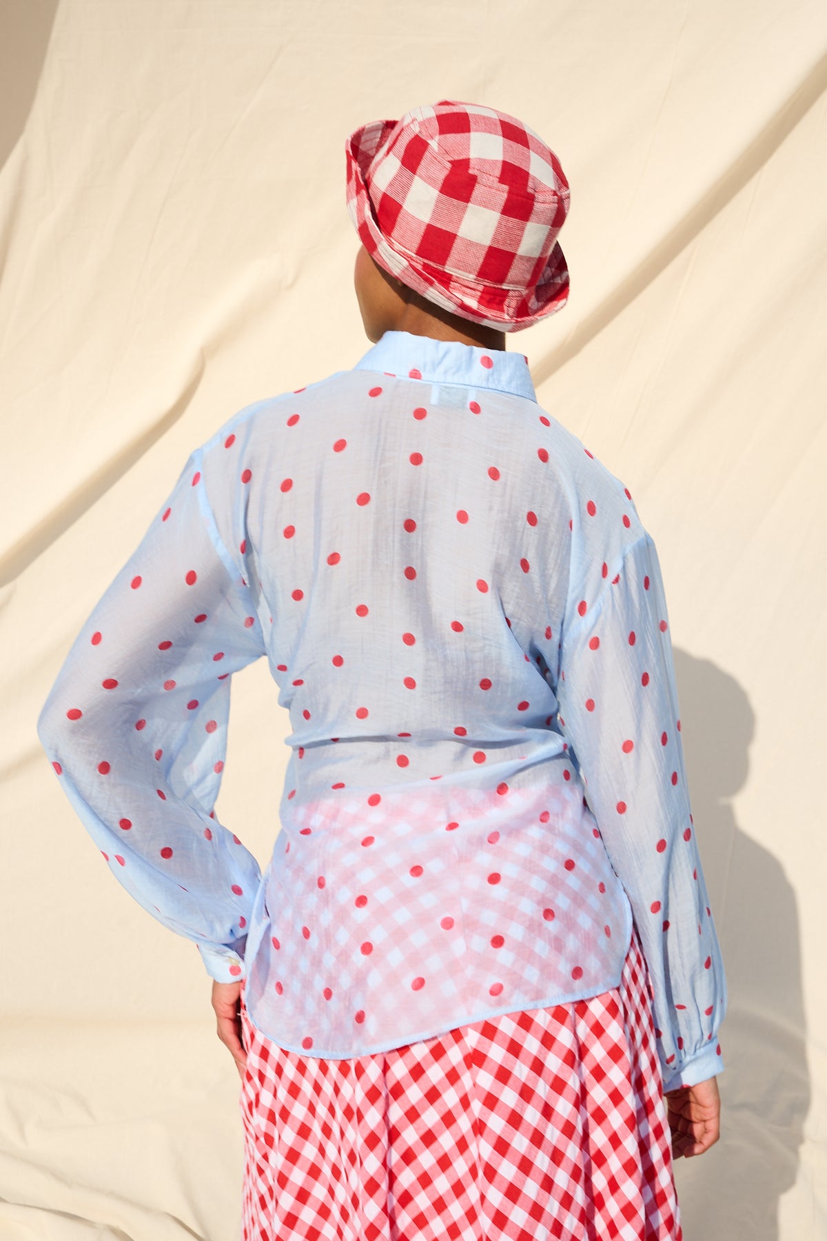 Light blue blouse with red polka dots, long sleeves and a tie waist