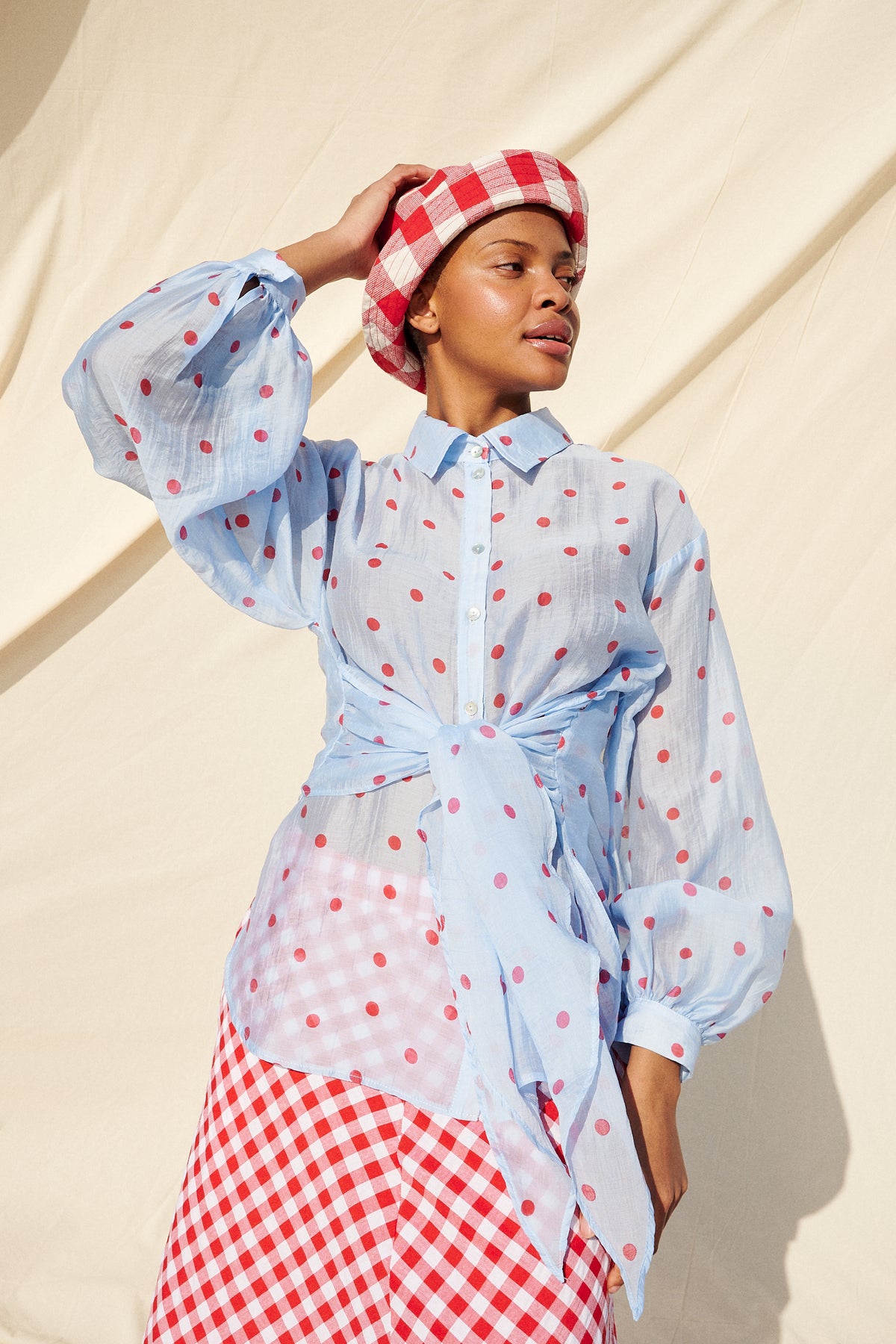 Light blue blouse with red polka dots, long sleeves and a tie waist