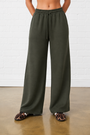 Model is wearing olive green elasticated waist wide leg joggers with leopard print shoes 