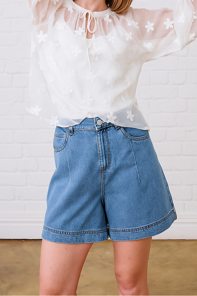 Model is wearing a medium wash denim shorts