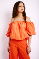 Model is wearing an off the shoulder bubble style top with short sleeves and elasticated top.
