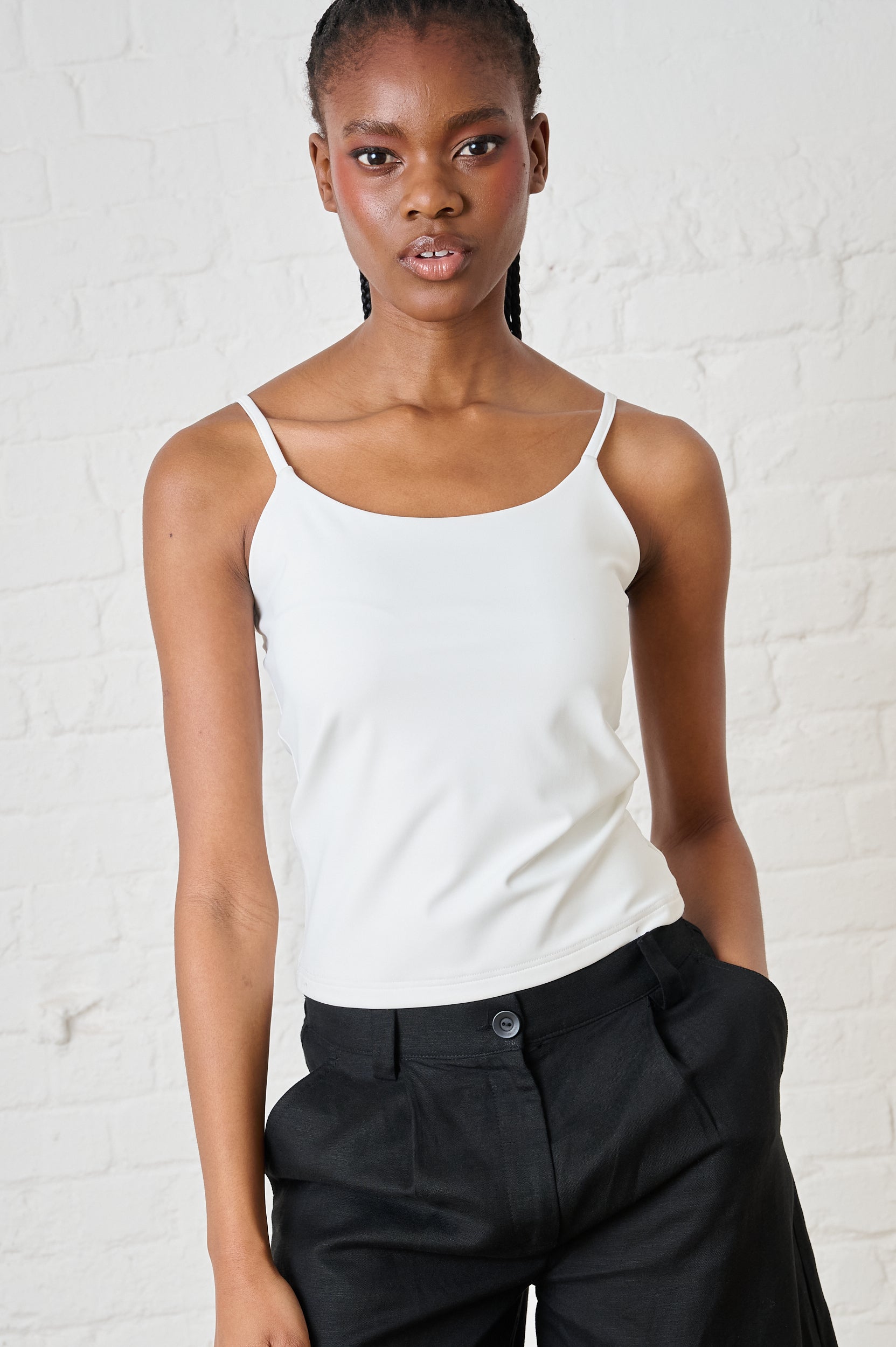 Model is wearing a milk colour camii with black pants 