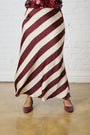 Model is wearing a burgundy stripe satin maxi skirt with burgundy shoes by Me&B