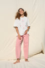 Model wearing white T-shirt with floral cross stitch detail