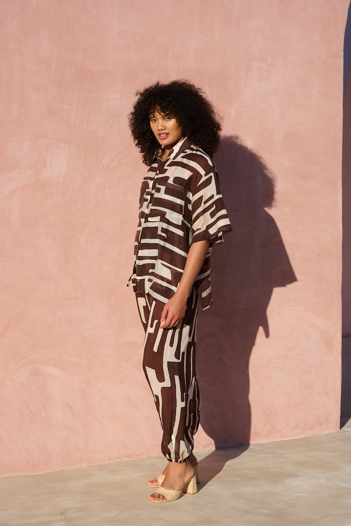 Model wearing oversized chocolate banana-print viscose short-sleeve shirt