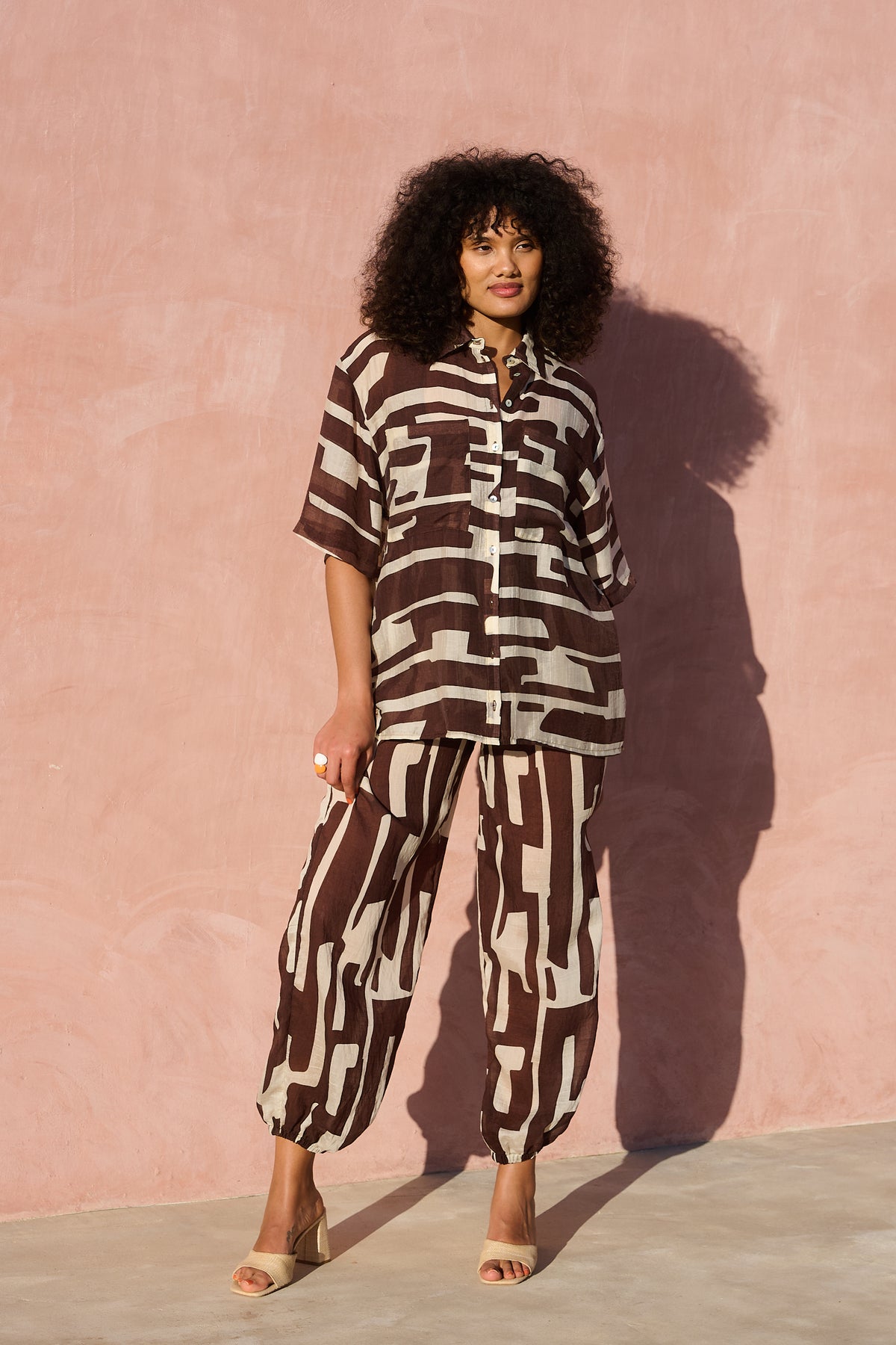 Model wearing oversized chocolate banana-print viscose short-sleeve shirt