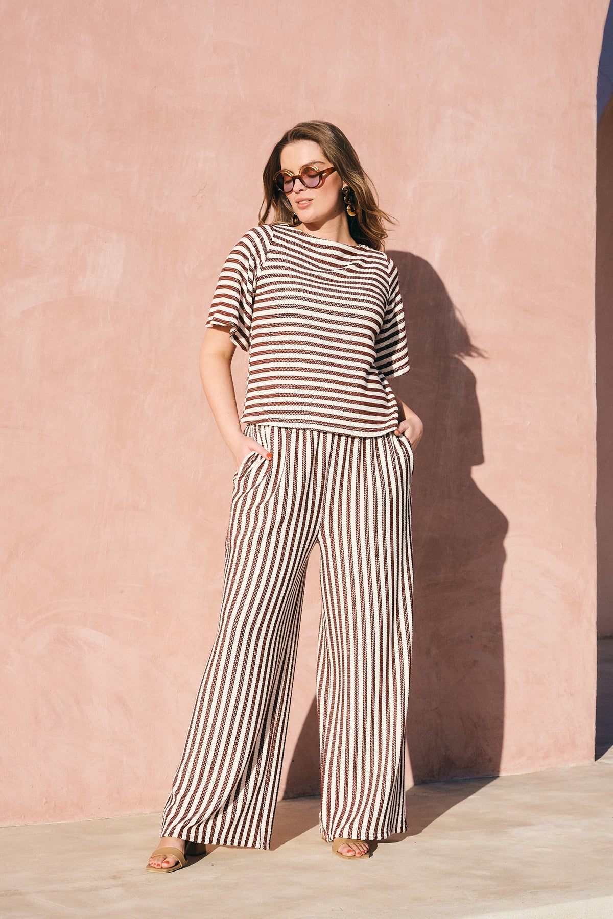 Model wearing chocolate and milk striped boat-neck knitted top