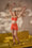 Model is wearing a shape wear bralette in a rust orange colour jumping on a couch