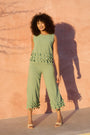 Model wearing shale green wide-leg cropped pants with tassel hems
