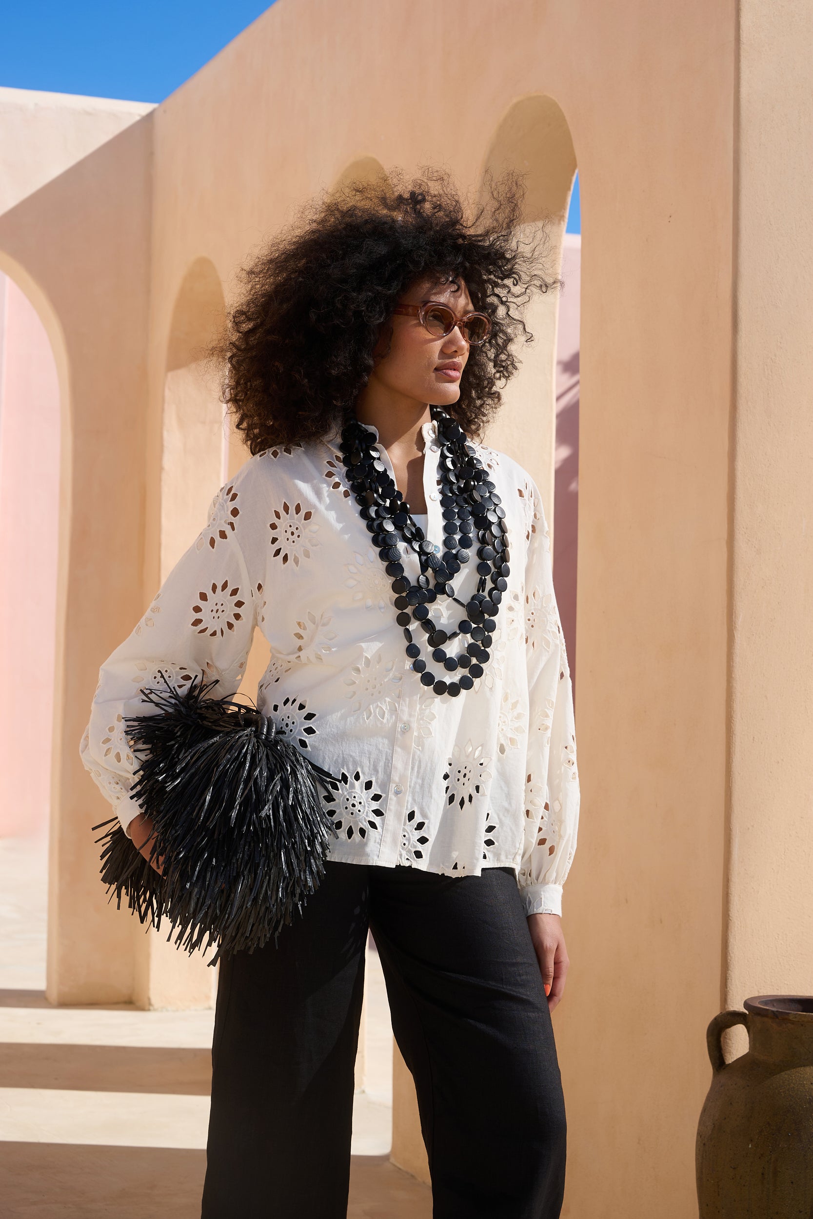 Model Is wearing a white anglaise detail shirt with black accessories
