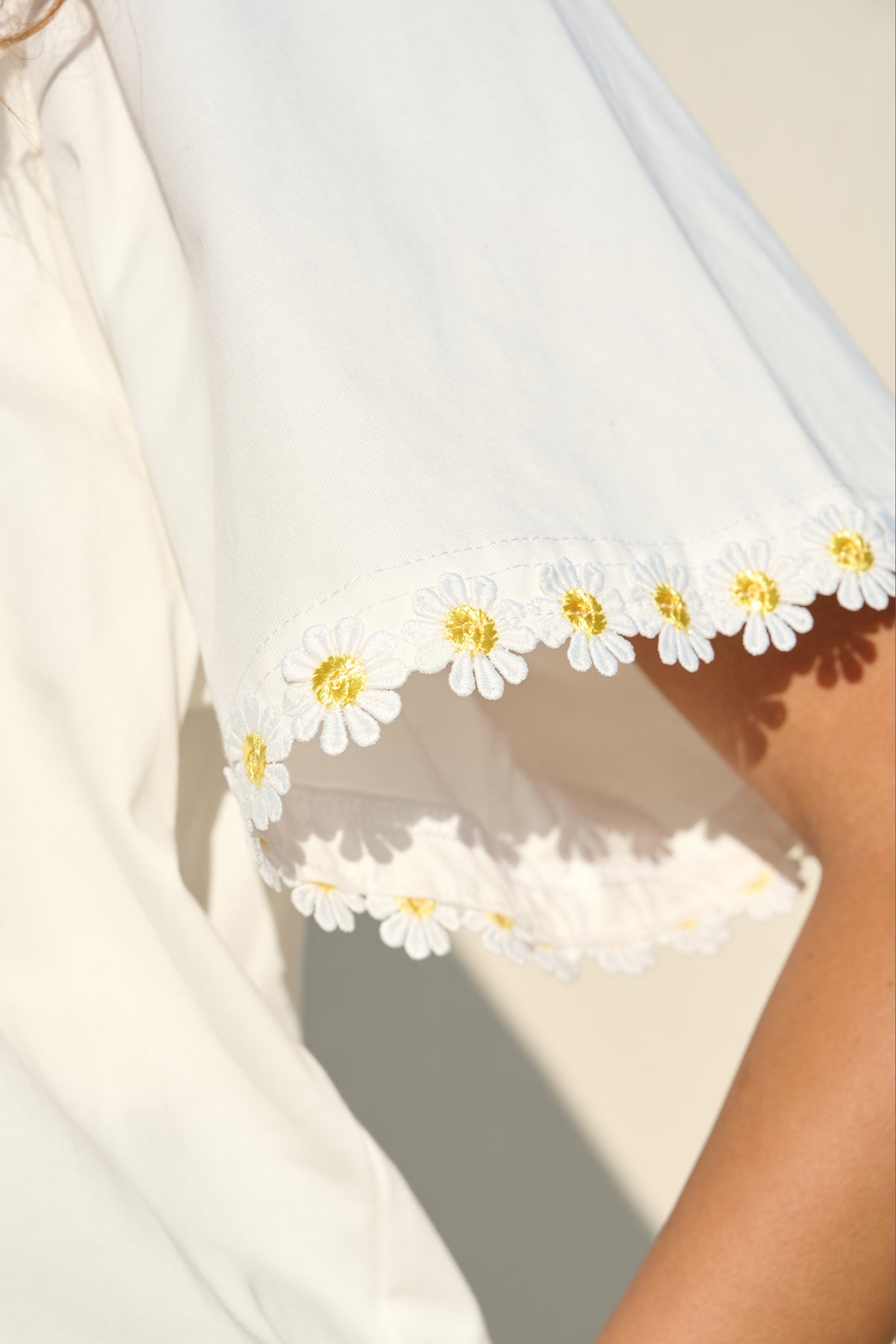 100% cotton white T-shirt with delicate yellow daisy trim sleeves