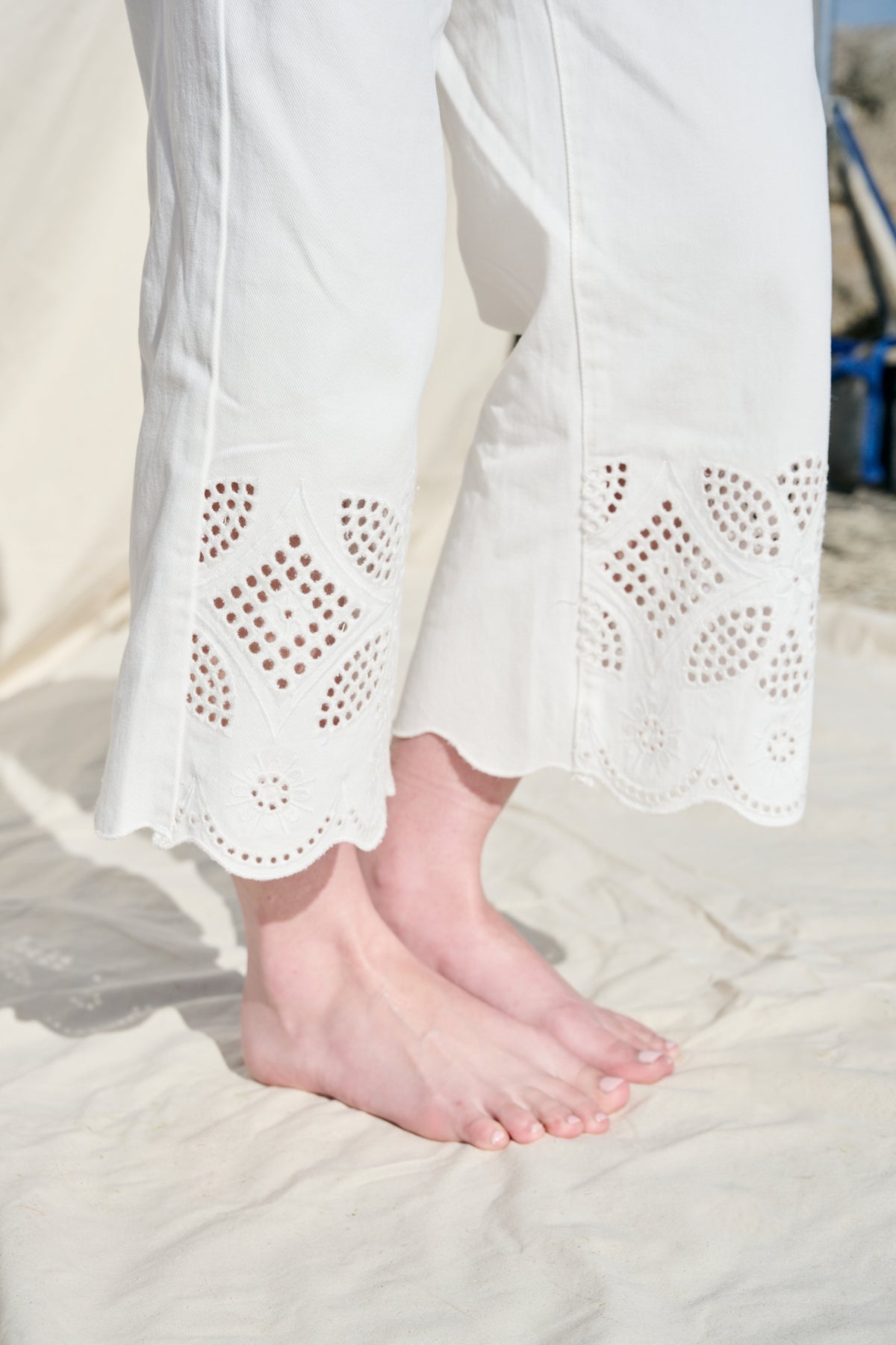 White cropped wide-leg jeans with broderie cutwork and scalloped hems