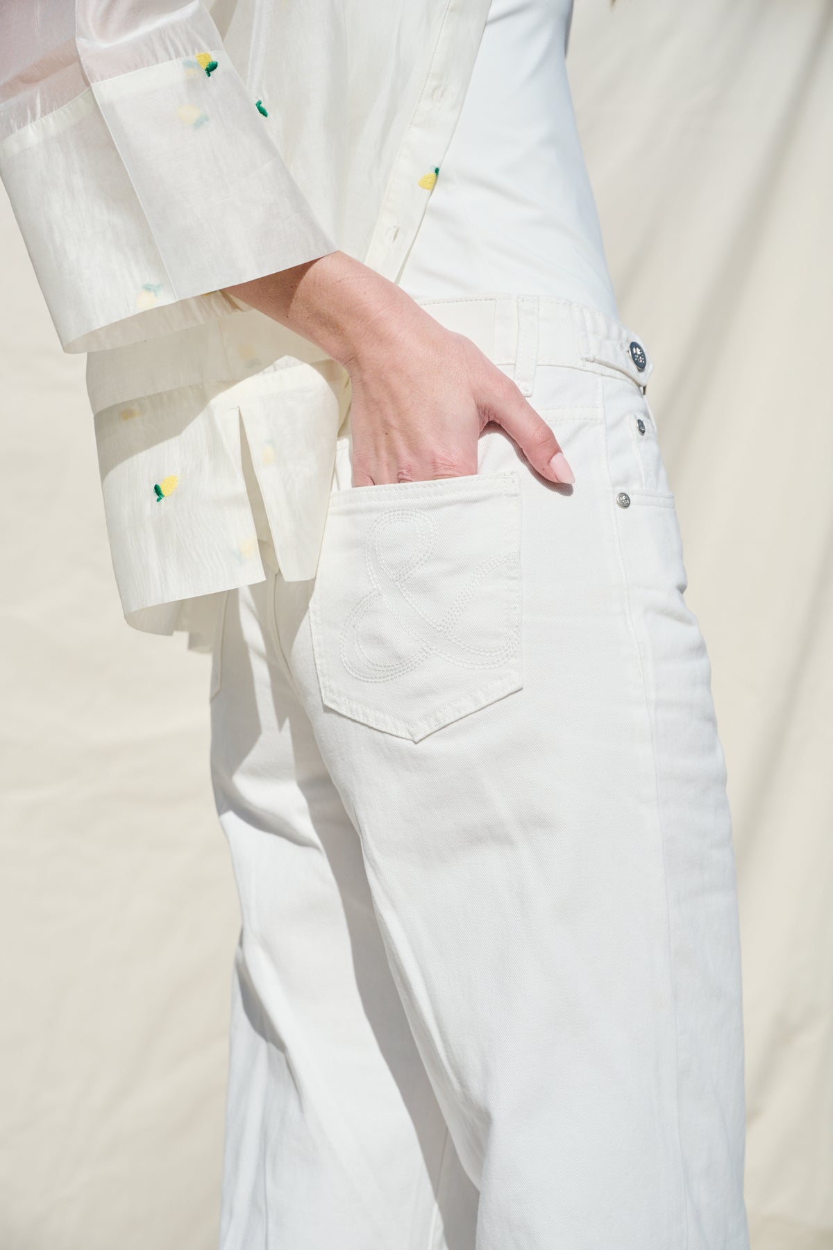 White cropped wide-leg jeans with broderie cutwork and scalloped hems