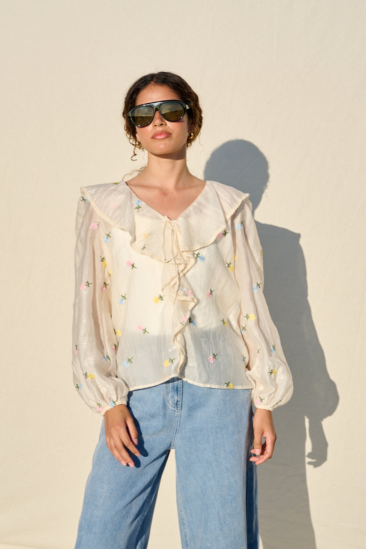 milk sheer blouse with floral embroidery, ruffle collar and tie front.