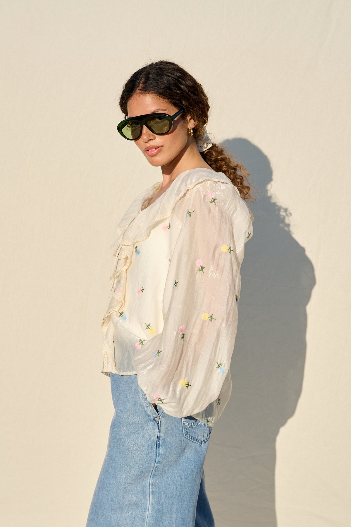 milk sheer blouse with floral embroidery, ruffle collar and tie front.
