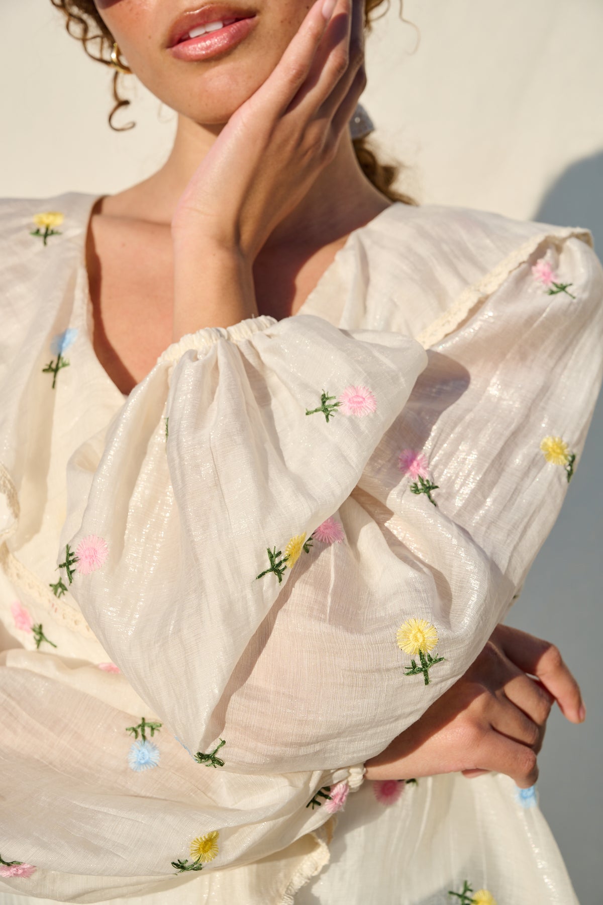 milk sheer blouse with floral embroidery, ruffle collar and tie front.