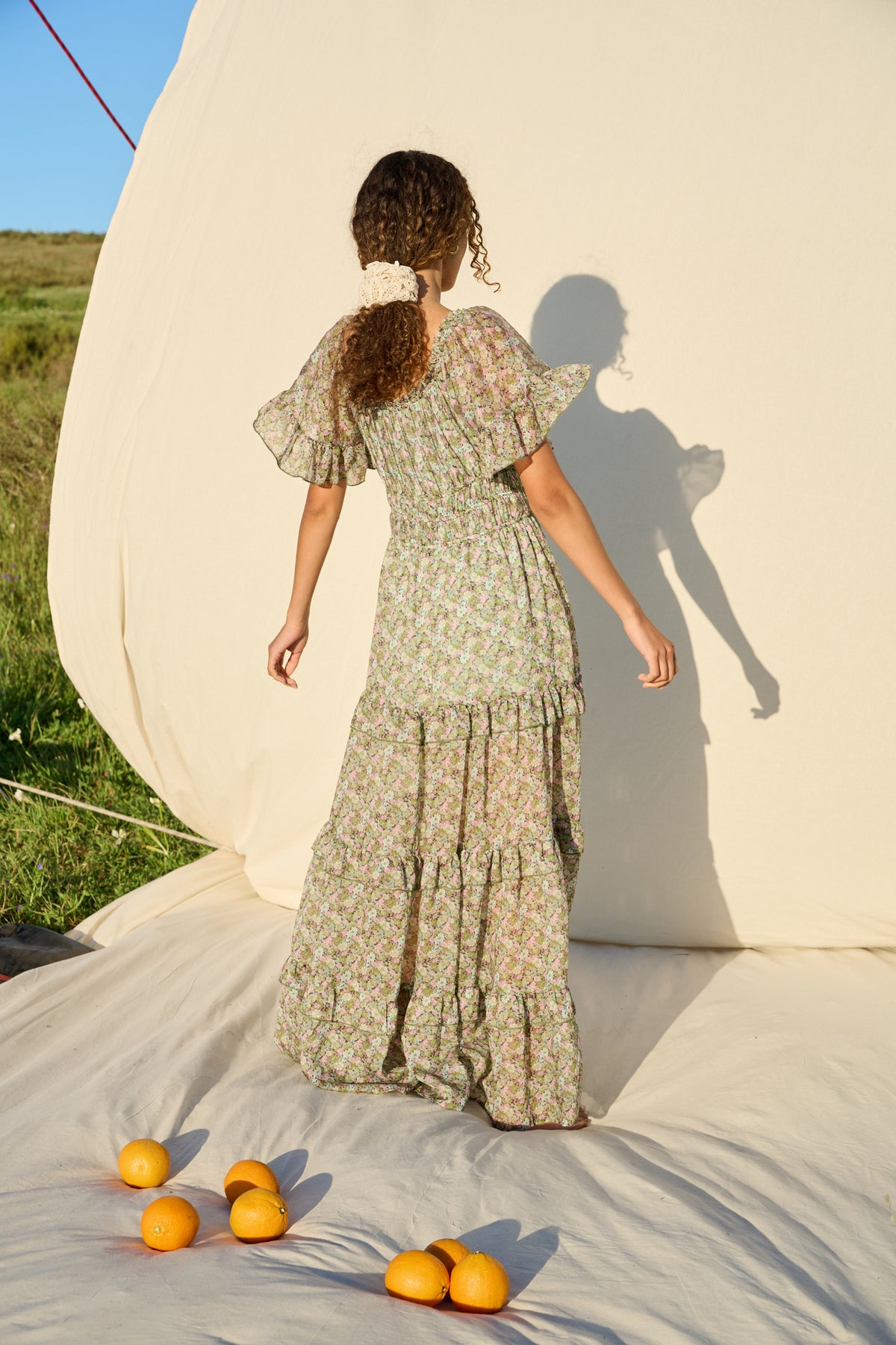 Pink and green floral maxi dress with flutter sleeves and tiered skirt