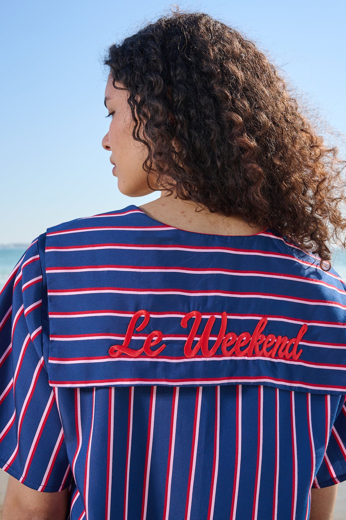 Close up of 'Le Weekend' Embroidery on the back of a navy and red striped sailor shirt 
