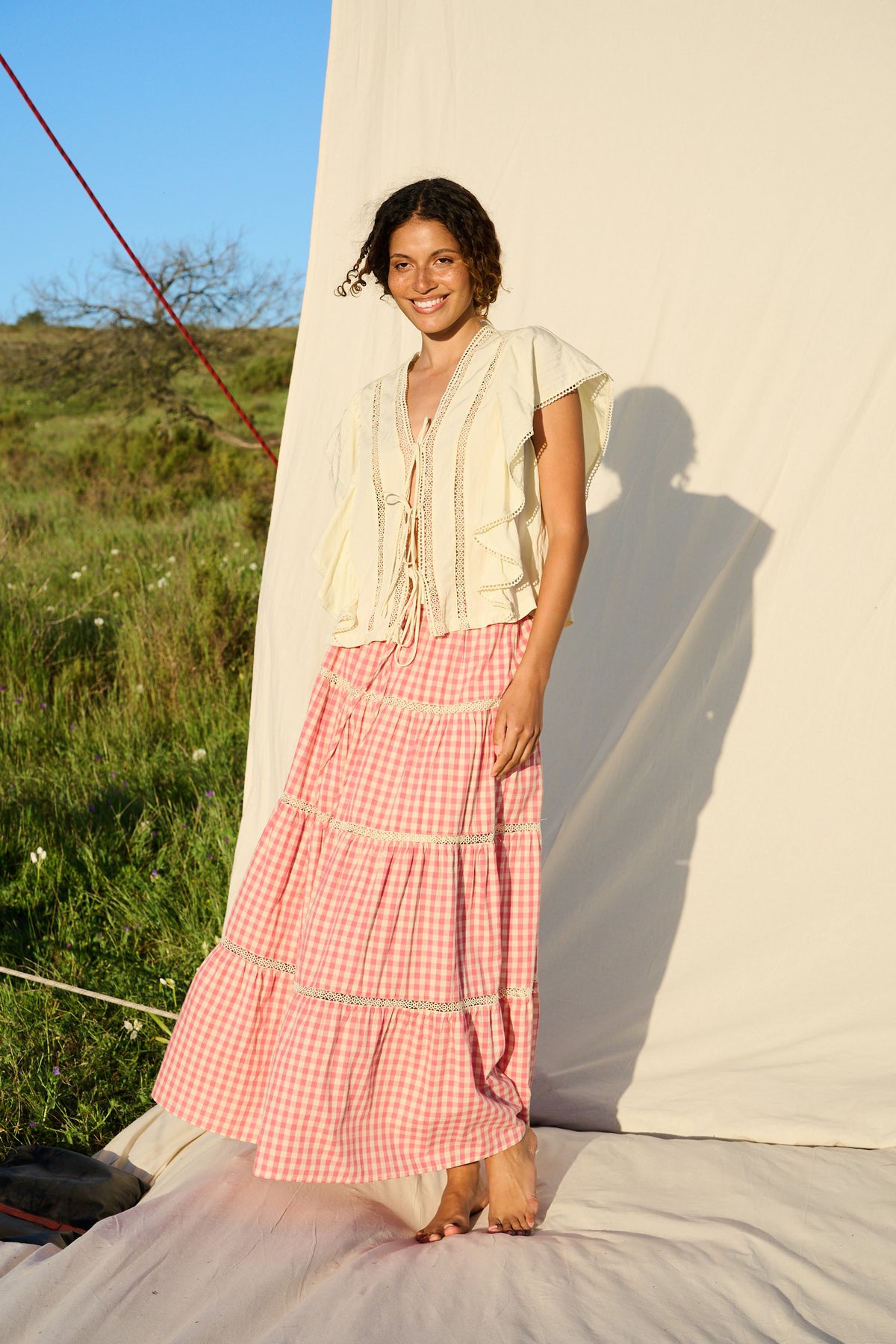 Butter yellow blouse with ruffle sleeves, lace trim and tie-front detail.