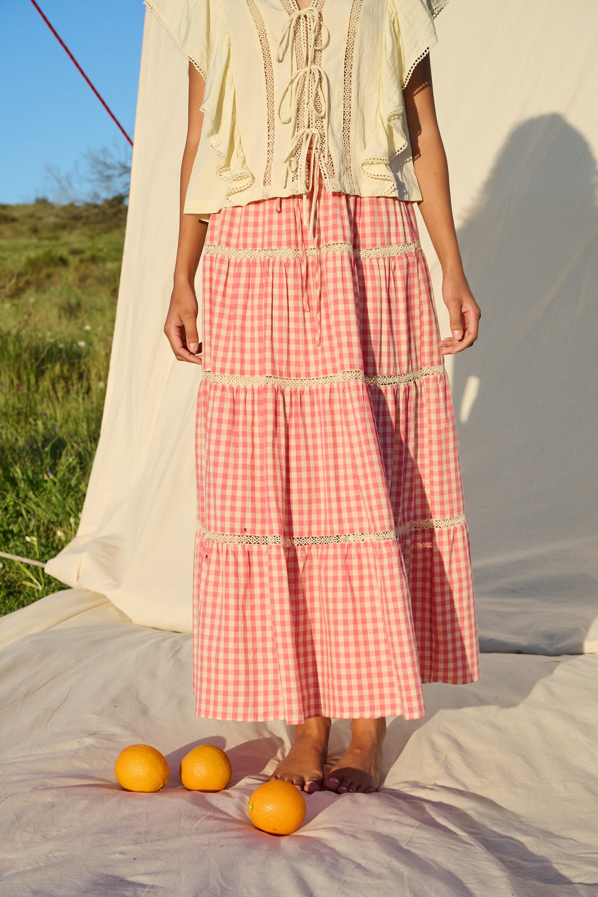 Pink gingham maxi skirt with lace trim and tiered ruffle detailing.