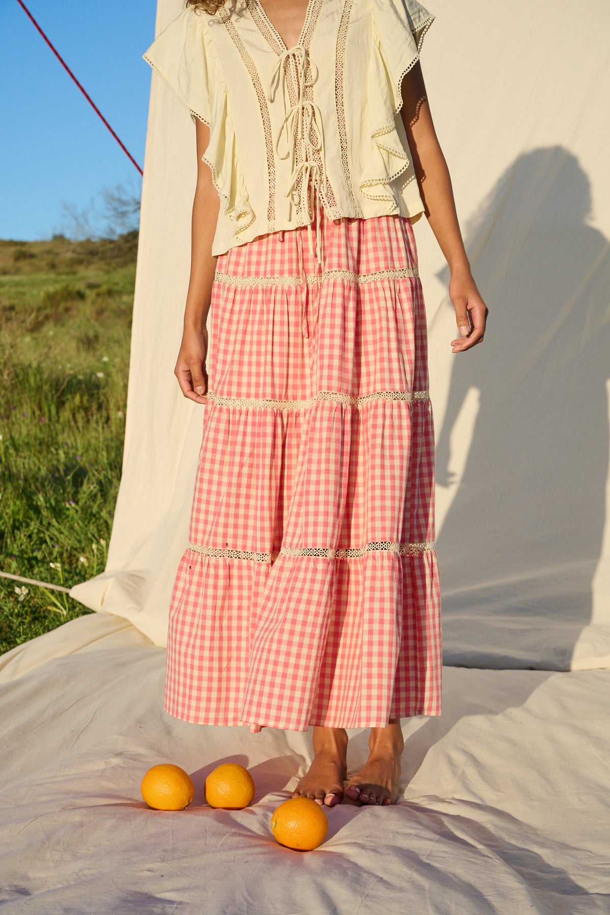 Pink gingham maxi skirt with lace trim and tiered ruffle detailing.