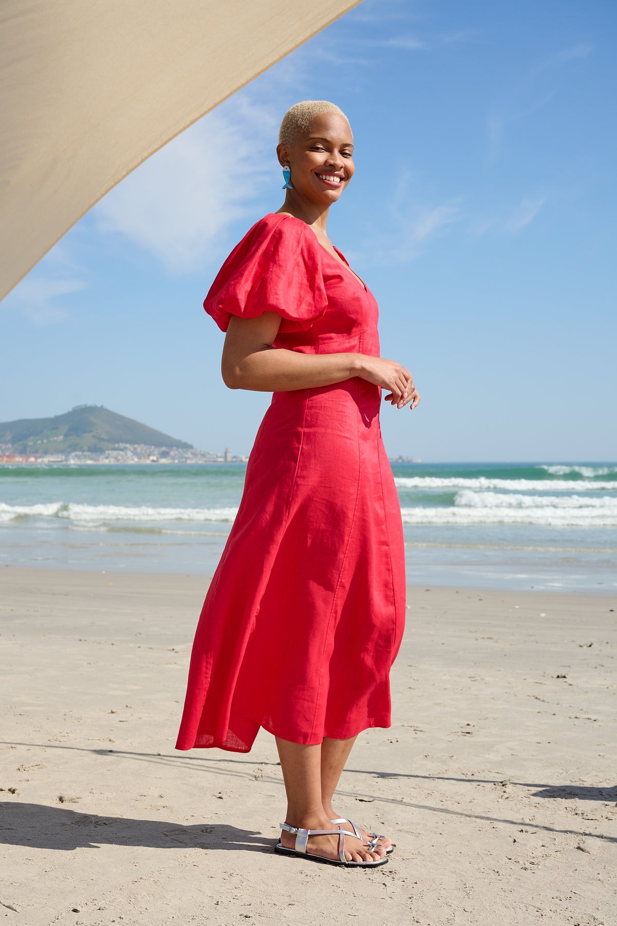 Woman wearing a red V-neck midi dress with puff sleeves on the beach