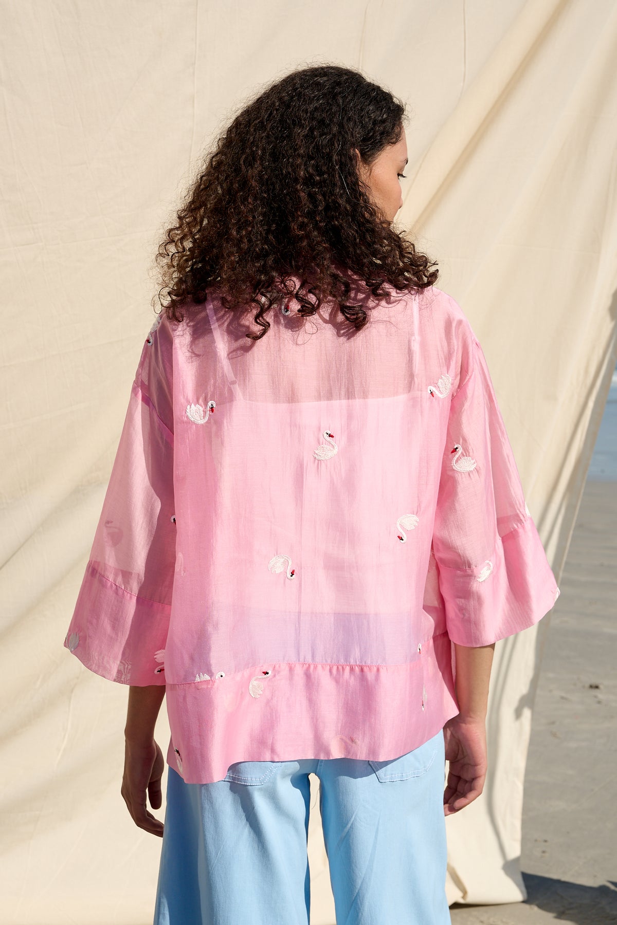 Pink oversized button-up shirt with embroidered swans and wide cuffs